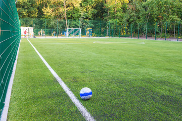 The ball lies on the green grass of the new football field