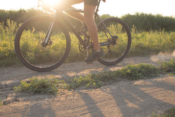 close up picture of bicycle rider hands and bike during sunset 