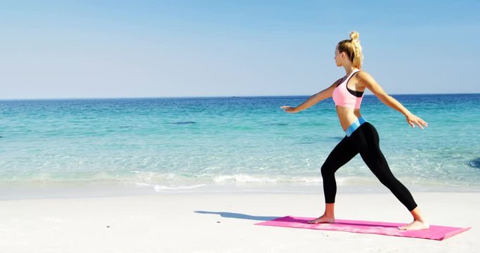 Fit woman doing stretching exercise at beach