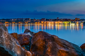 The lights of the Eastern European city are reflected in the lake.