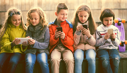 children playing with the phone on bench outdoors