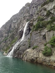 Fototapeta na wymiar Waterfall in to the Norwegian fjord