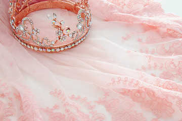 Vintage tulle pink chiffon dress and diamond tiara on wooden white table