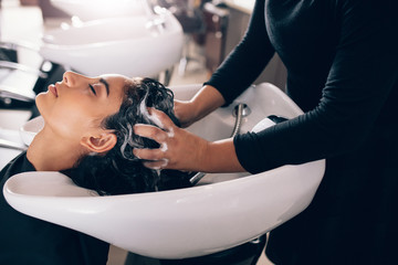 Woman getting hair shampooed at salon - obrazy, fototapety, plakaty