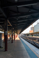 An empty train station platform and empty railway at Sydney Central station
