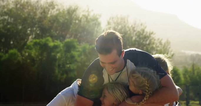 Happy coach hugging a children in park