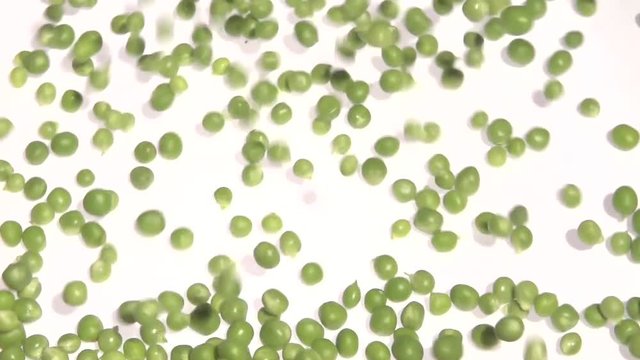 Green pea. The young peas drop on the table and roll. Slow motion 240 fps. Slowmo. High speed camera shot. Full HD 1080p. 