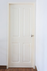 white wood pane door closed and silver knob lock in industrial building house