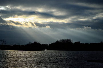 Zachmurzone niebo nad jeziorem i smuga światła