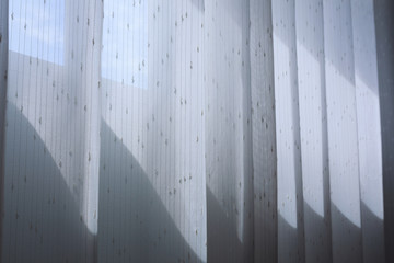 white drapery curtain hanging on the window
