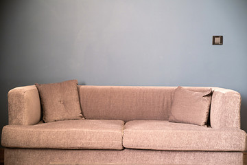 brown sofa in front of blue wall