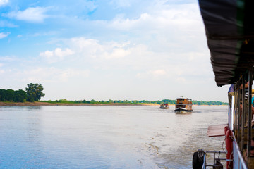 Obraz premium Tourist boats on the Irrawaddy river, Mandalay, Myanmar, Burma. Copy space for text.