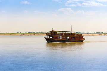 Fototapeta premium Pleasure boat on the river Irravarddy, Mandalay, Myanmar, Burma. Copy space for text.