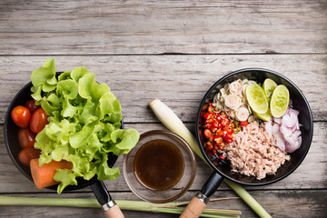 Spicy tuna salad on wood background