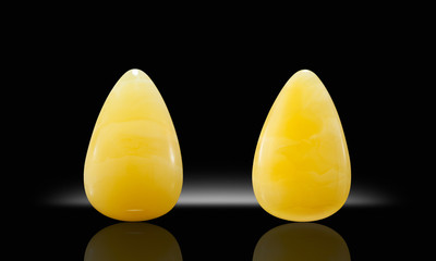 Amber succinite cabochon front and back on black background