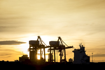 silhouette industrial shipping port and sunrise, transportation import export