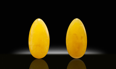 Amber succinite cabochon front and back on black background