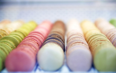 Colorful roundish sweets macarons in a box on the showcase of the bakery shop.