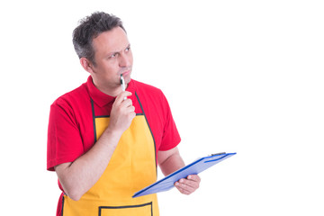 Pensive employee with clipboard looking doubtful