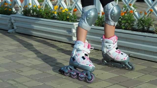 Feet of the child on rollers. The child learns to skate.