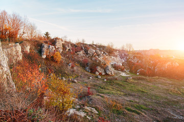 View on the beautiful colorful autumn landscape of the hills with trees, rocks and greenfields in the countryside