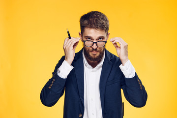 Business man with a beard in glasses on a yellow background