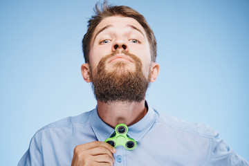 Man with a beard on a blue background holds a spinner