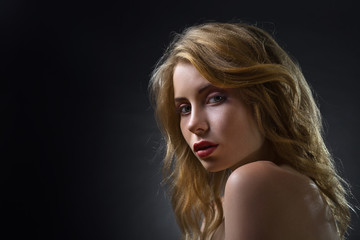 Fototapeta premium Attractive blonde woman on dark background .