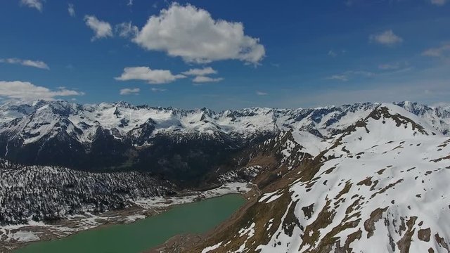 Aerial view on Ritom lake between snow-capped mountains at spring, Switzerland alps, 4k
