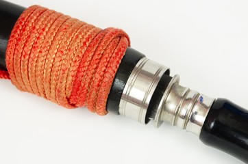 Thai sword made of stainless steel with wooden handle black ropes red isolated on white background. Ancient weapon.