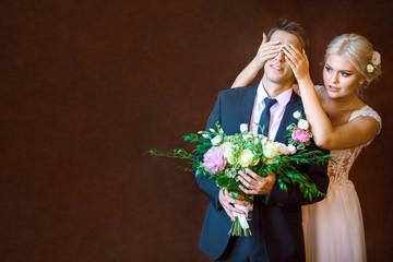 the bride closes to groom's eyes in the studio