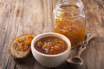 Cloudberry jam in a glass jar and bread with jam