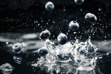 ripe blueberries dropping in water