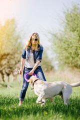 The blonde is playing with a labrador.