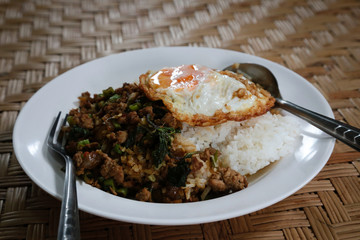 Popular food of Thailand is fried rice basil leaf with pork and fried egg on top.