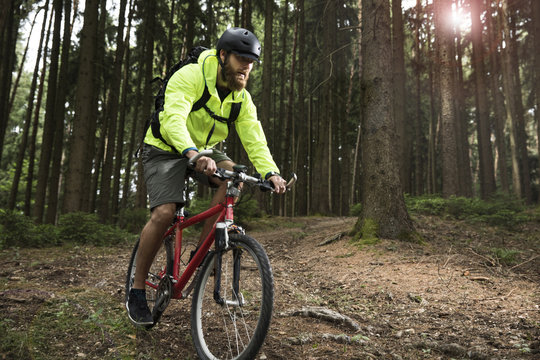 Man mountain biking in forest
