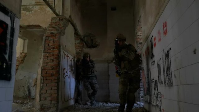 Young soldiers training for counter terrorist operation in bombarded building