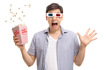 Naklejka premium Terrified guy with a pair of 3D glasses and popcorn