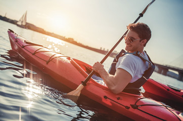 Man kayaking on sunset