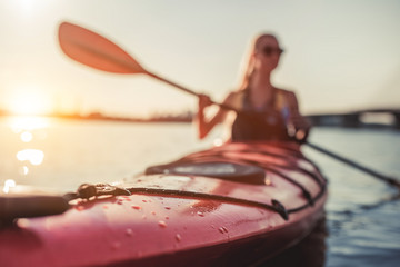 Woman kayaking on sunset