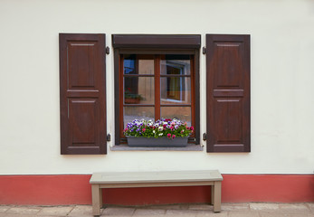 Beautiful window with flowers and shutters in the old town in Vilnius