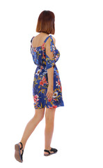 back view of walking woman.   beautiful blonde girl in motion.  backside view of person.  Rear view people collection. Isolated over white background. The girl in a dress in a flower leaves sideways