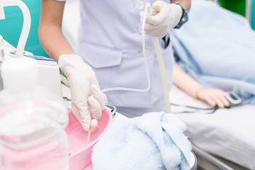 Nurse use Suction Machine, prepare to suction patient's mucus. Soft focus.