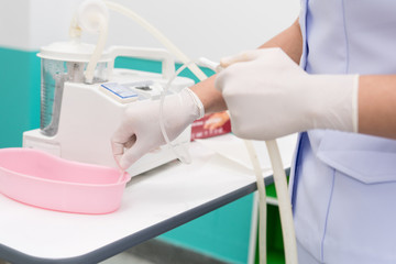 Nurse use Suction Machine, prepare to suction patient's mucus. Soft focus.