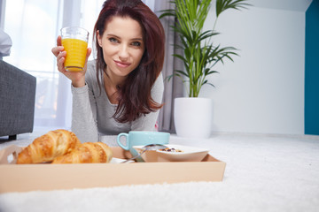 Beautiful happy woman having breakfast in bed