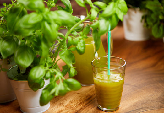 Fresh organic green smoothie with spinach, cucumber, parsley, celery on wooden background