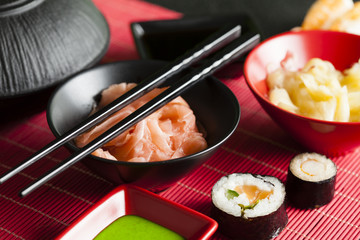 Sushi rolls, ginger and wasabi on red mat