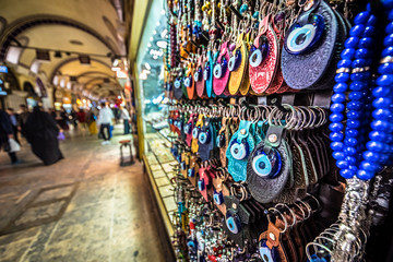 ISTANBUL, TURKEY- APRIL 17, 2017: Unidentified Tourists visiting and shopping in the Grand Bazaar in Istanbul. Interior of the Grand Bazaar with souvenirs on the foreground