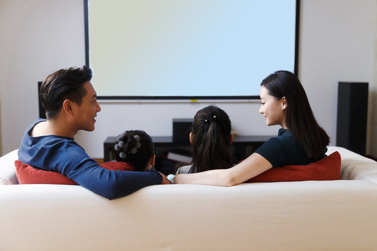 Happy Family Watching TV In Sofa,back View