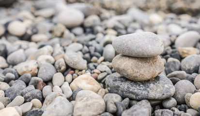 Fototapeta na wymiar Small tower made of pebbles on a rocky beach